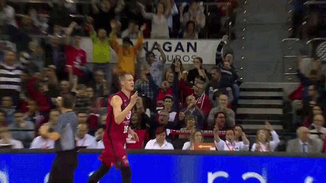 a basketball player in front of a sign that says ' nagan equipos '