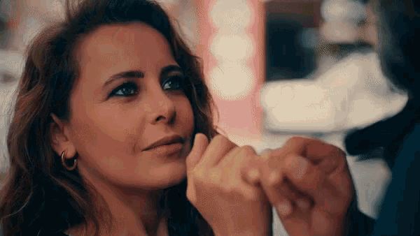 a woman is holding a man 's hand and looking at him