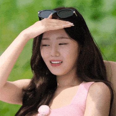 a woman wearing sunglasses and a pink tank top