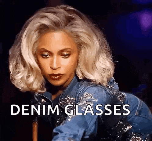 a woman wearing a denim jacket and denim glasses .