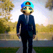 a man in a suit and tie is wearing a mask with a k on it