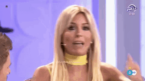 a woman in a yellow dress is talking on a television show