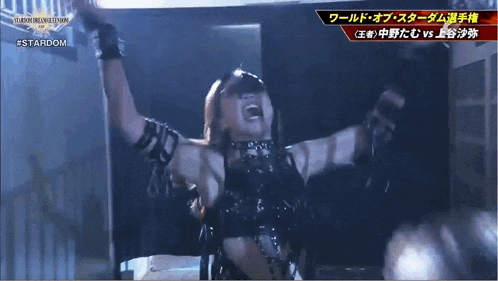 a woman in a black outfit is screaming in front of a screen that says #stardom
