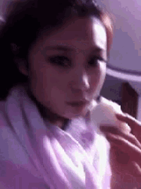 a woman in a purple robe is eating a piece of food .