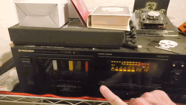 a pioneer cassette player sits on top of a metal shelf