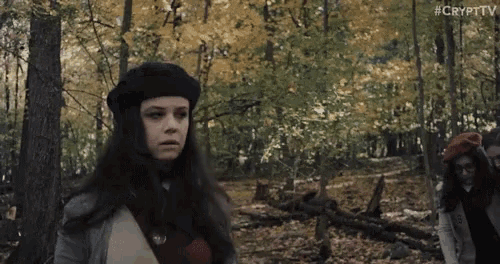 a woman in a black beret stands in the woods with the hashtag #crypttv on the bottom