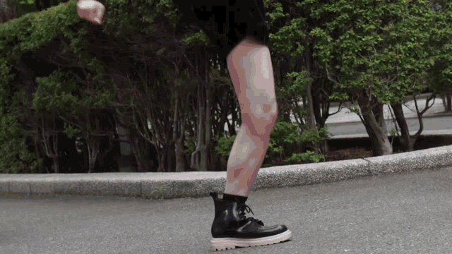 a woman wearing black boots with a pink sole