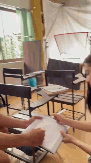 a group of people sitting at desks in a classroom with papers in their hands