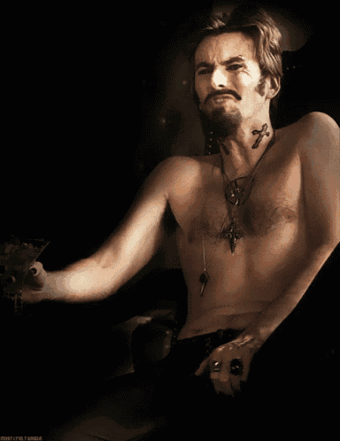 a shirtless man with a cross tattoo on his chest