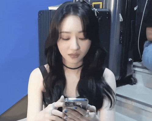 a woman is holding a cell phone in her hands
