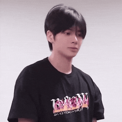 the boy is wearing a black t-shirt with flames on it .