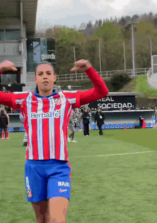a woman in a red white and blue striped shirt with herbalife on it