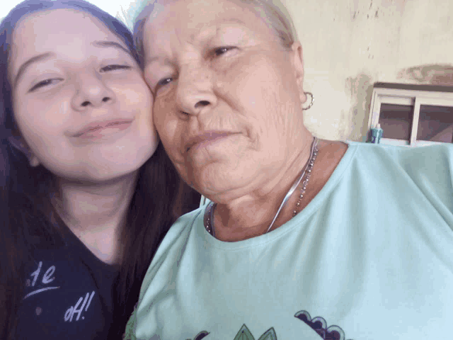 a young girl kisses an older woman on the nose