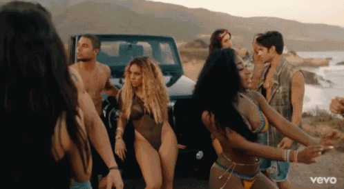 a group of people are dancing in front of a jeep with the word vevo on the bottom