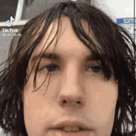 a close up of a man 's face with a very long haircut .