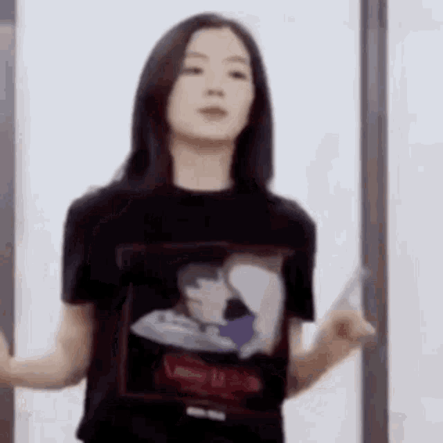 a woman wearing a black t-shirt with a picture of a man and woman on it .