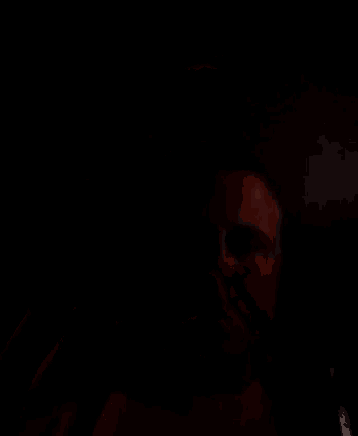 a man in a dark room is holding a bottle