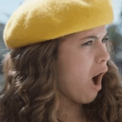 a woman wearing a yellow beret is yawning with her mouth wide open .