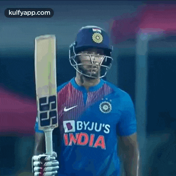a cricket player is wearing a helmet and holding a bat in his hand .
