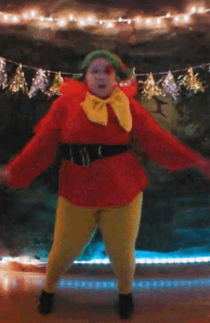 a woman dressed as a christmas elf is dancing