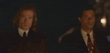 a group of people are standing next to each other in a dark room .