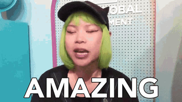 a woman with green hair and a black hat is saying amazing