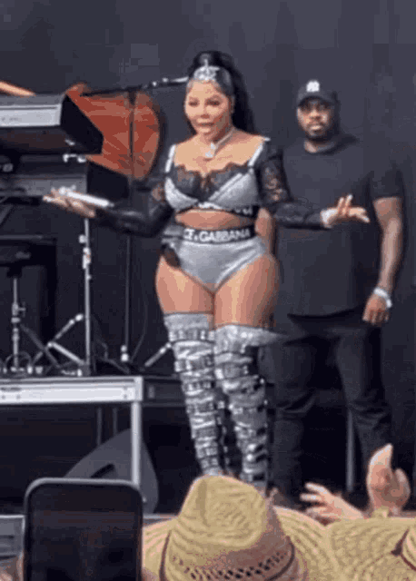 a woman in a dolce & gabbana outfit stands in front of a crowd