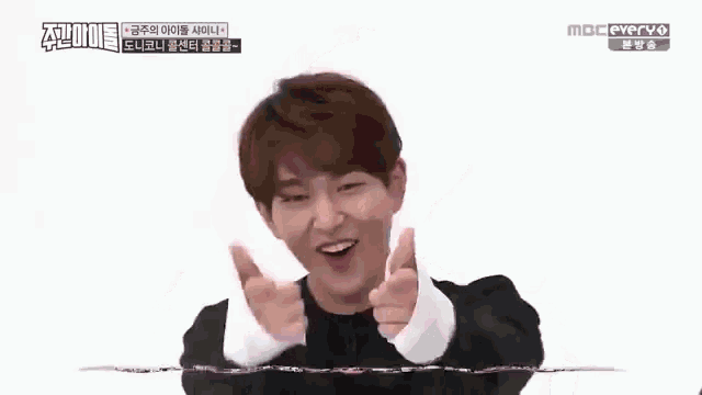 a young man is making a funny face with his hands in the air while talking in a foreign language .