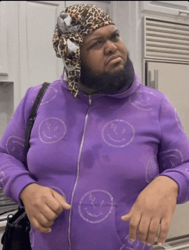 a man with a beard wearing a purple jacket with smiley faces on it