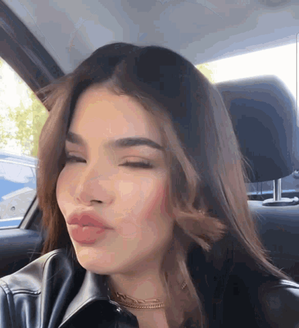 a woman in a car with her eyes closed
