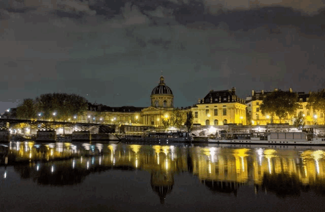 a building with a dome on top of it is reflected in a body of water