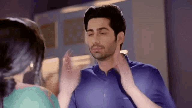 a man and a woman are touching each other 's faces .
