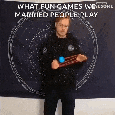 a man is playing a game in front of a tapestry that says `` what fun games we married people play '' .