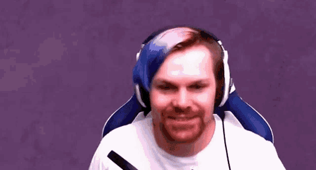 a man with a beard and blue hair is wearing headphones and a microphone .