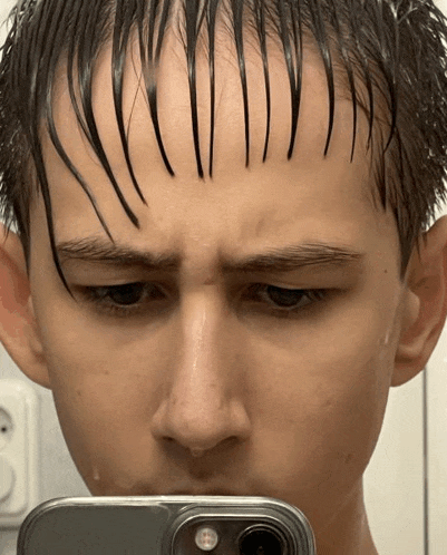 a young man taking a picture of himself with a cell phone