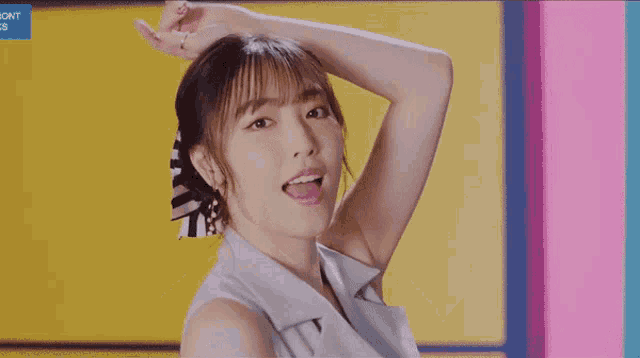 a girl with a ponytail and a bow in her hair looks at the camera