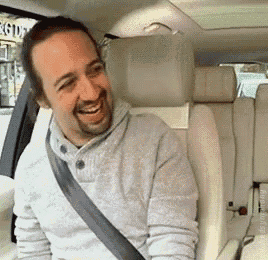 a man is sitting in the back seat of a car with a seat belt around his neck .