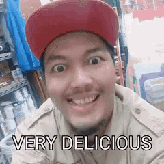 a man wearing a red hat is smiling with the words very delicious behind him