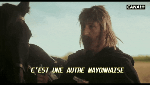 a man holding a gun with the words c'est une autre mayonnaise on the screen