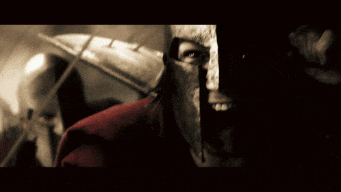a close up of a man wearing a helmet and a red jacket