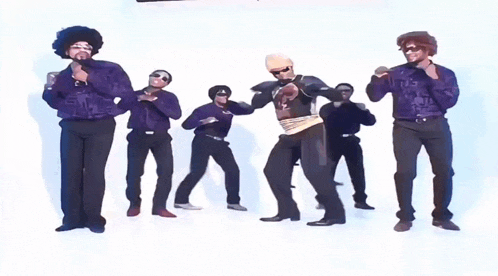 a group of men in purple shirts and black pants are standing in a line