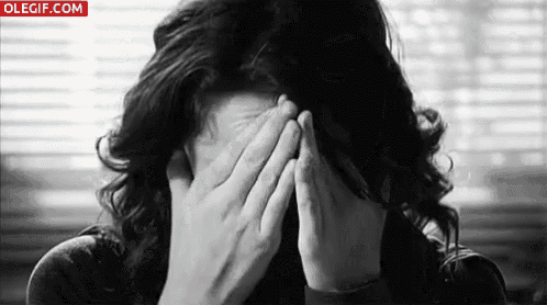 a woman covering her face with her hands in a black and white photo