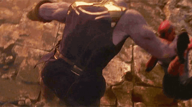 a man in a purple suit is fighting another man in a red glove .