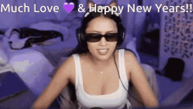 a woman wearing sunglasses and headphones says " much love & happy new years "