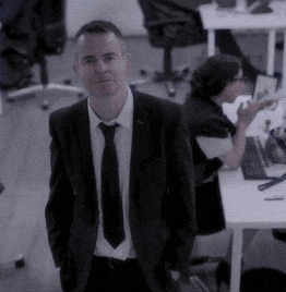 a man in a suit and tie is standing in an office