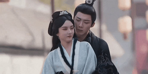 a man and a woman are standing next to each other .