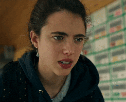 a close up of a woman 's face with a blue hoodie on