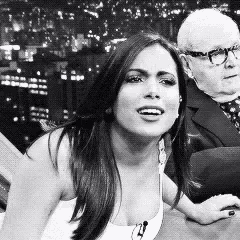 a black and white photo of a woman with a man in the background