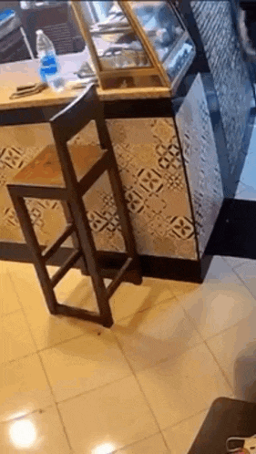 a wooden bar stool is leaning against a counter in a bakery .