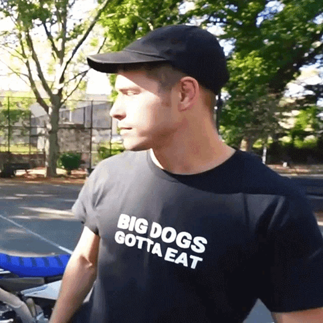 a man wearing a big dogs gotta eat shirt
